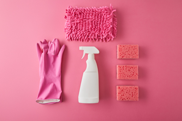 tendido plano con aerosol botella, esponjas, trapo y guantes de goma para la limpieza de la casa en rosa
 - Foto, Imagen