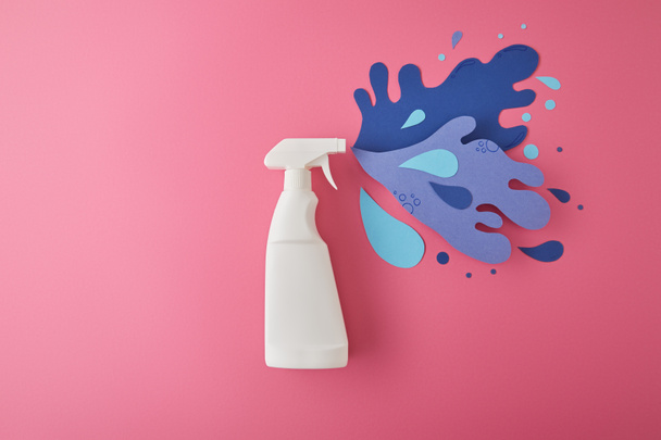 composición con botella de detergente spray y salpicadura de agua de papel, en rosa
 - Foto, Imagen