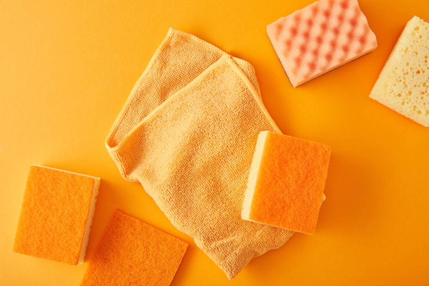 top view of rag and sponges for house cleaning on orange - Φωτογραφία, εικόνα
