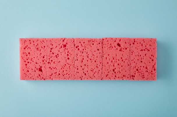top view of row of pink sponges for house cleaning on blue - Photo, Image