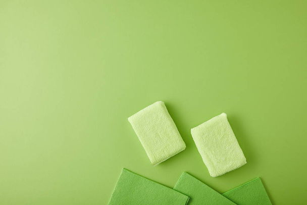 vista superior de esponjas y trapos para la limpieza de la casa en verde
 - Foto, imagen