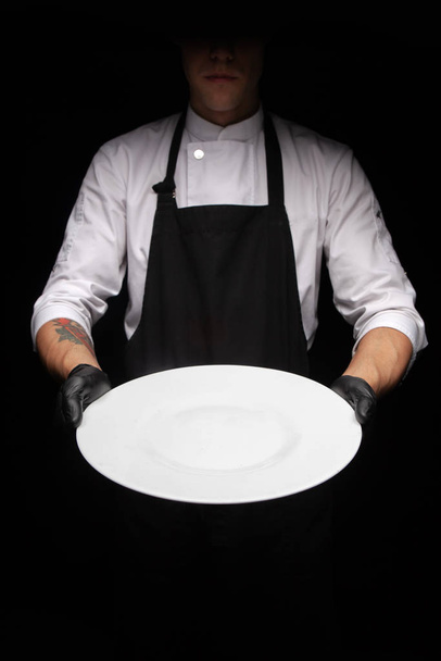 cook man holding a white plate - Foto, Imagen