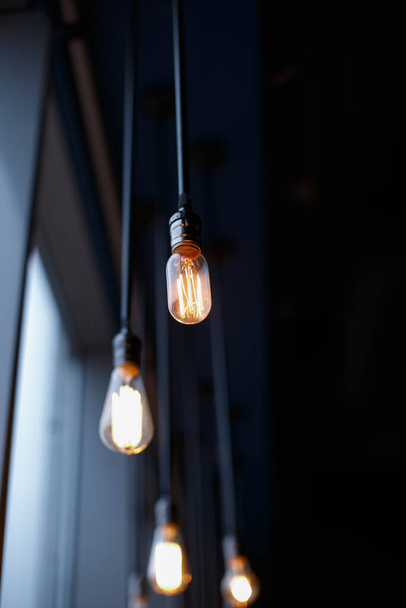 Ретро лампочки со слабым свечением висит на проводах к потолку
. - Фото, изображение
