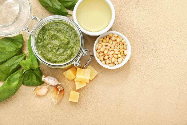 Bowl with pesto sauce and ingredients on color background - Foto, imagen