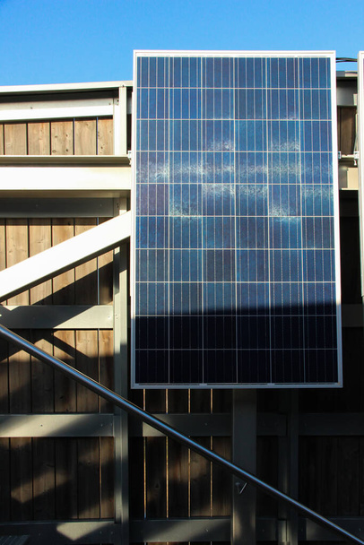 A napelem a napenergiát erősíti. Alternatív energiaforrás, amely környezetbarát. Napelem telepítve az épület tetejére.    - Fotó, kép
