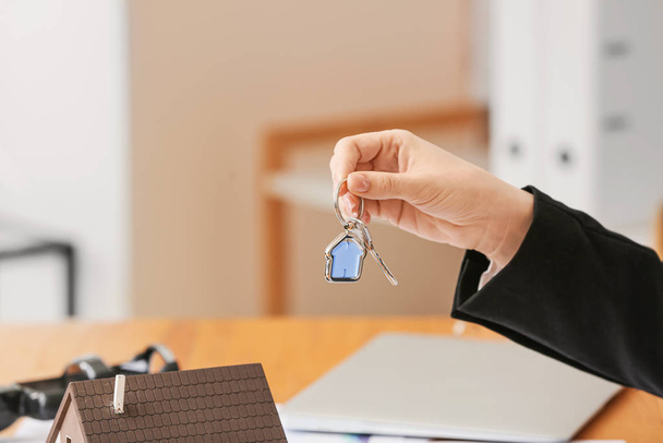 Агент по недвижимости с ключом в офисе
 - Фото, изображение