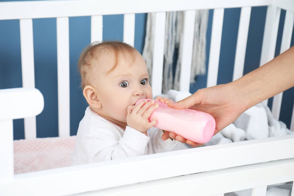 ベッドルームで哺乳瓶からミルクと母親の給餌 - 写真・画像