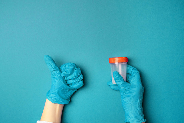 Arzthände in Latex-Handschuhen halten einen leeren Plastikbehälter und zeigen wie eine Geste - Foto, Bild
