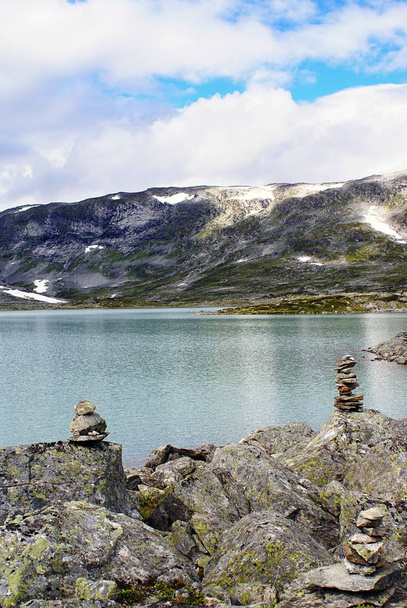 Vertical shot of a beautiful lake surrounded by high rocky mountains in Norway - Foto, imagen