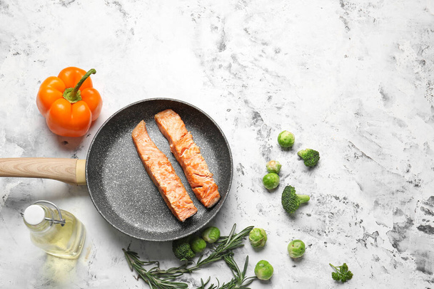 Frying pan with tasty cooked salmon on white background - Foto, imagen