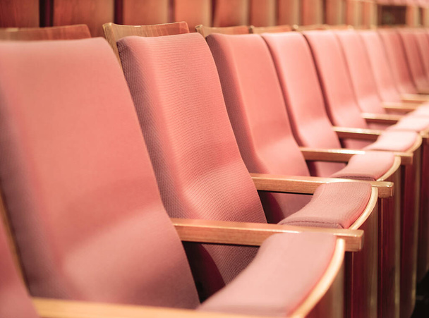 Selektiver Fokus leerer Stuhlreihen im Saal. leere rosa Stühle in Konferenzsaal oder Theater.  - Foto, Bild