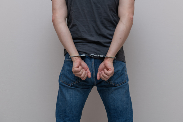 Adult prisoner male hands with handcuffs. Arrested man. Criminal concept. - Foto, imagen