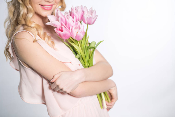 Luxurious blonde with a bouquet of tulips - Fotoğraf, Görsel