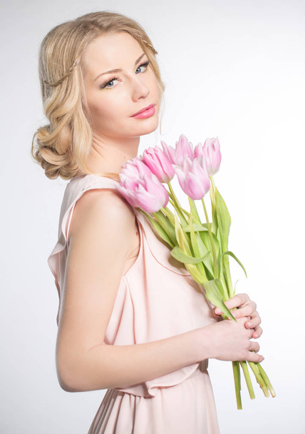 Luxurious blonde with a bouquet of tulips - Фото, зображення