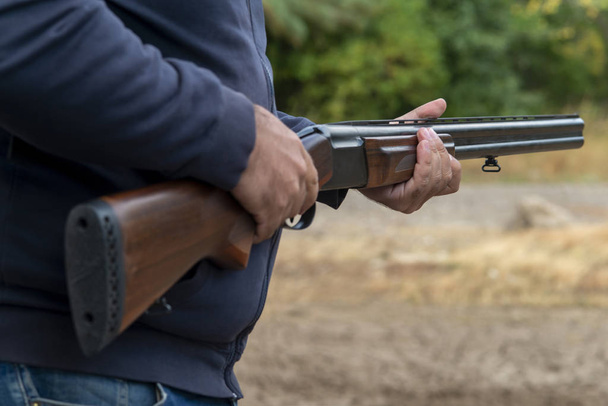 Erkek avcı av tüfeğiyle avlanmaya hazır. Avcı tüfeğini tutuyor.. - Fotoğraf, Görsel