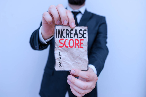 Text sign showing Increase Score. Business photo showcasing statistical number that evaluates a consumer creditworth Male human wear formal work suit office look hold notepaper sheet use hand - Photo, Image