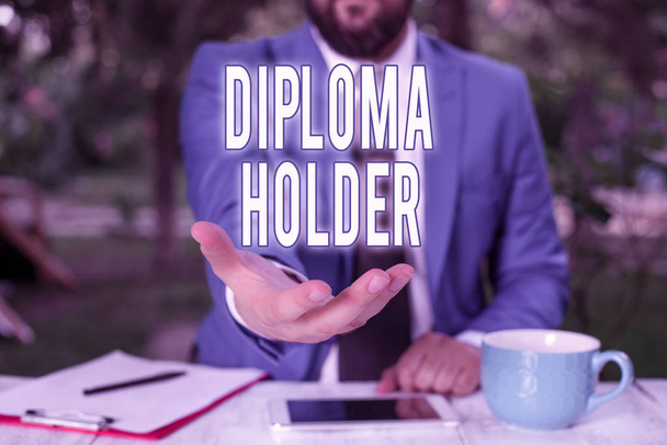 Word writing text Diploma Holder. Business photo showcasing a demonstrating successfully completed a particular course of study Man with opened hands in fron of the table. Mobile phone and notes on the table - Photo, Image