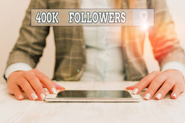 Text sign showing 400K Followers. Business photo showcasing number of individuals who follows someone in Instagram Business woman sitting with mobile phone on the table - Fotoğraf, Görsel
