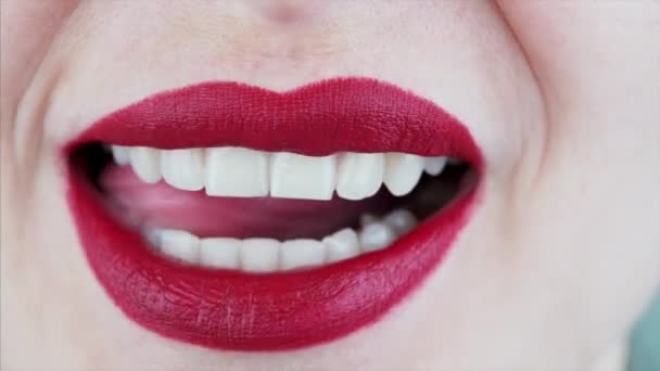 Nahaufnahme von weiblichen Mund und Zunge lecken Lippen mit sexy roten Lippenstift und zeigt perfekte weiße Zähne - Filmmaterial, Video