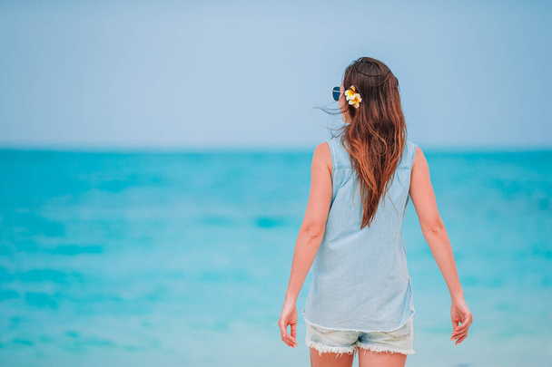 Vrouw liggend op het strand genietend van de zomervakantie kijkend naar zee - Foto, afbeelding