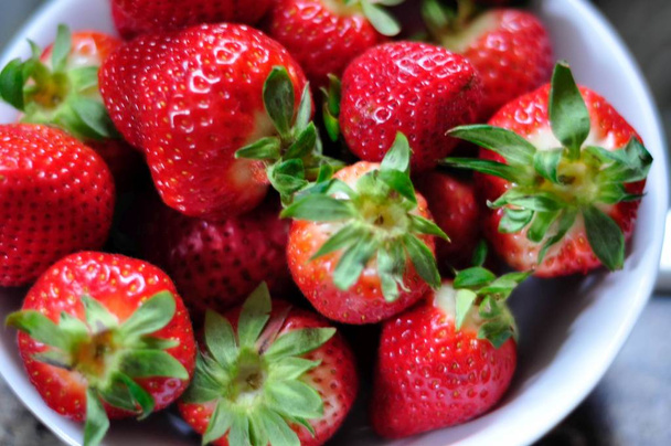 A high angle closeup shot of fresh strawberries in a bowl - Foto, Imagen