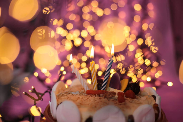 Burning candle in the cake festive bright pink background birthday macro photo - Photo, Image