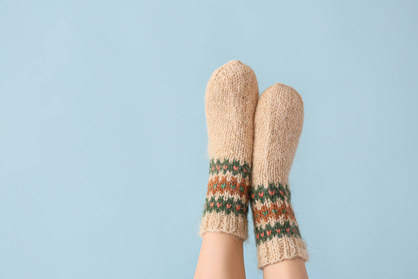 Legs of young woman in warm knitted socks on color background - Fotoğraf, Görsel