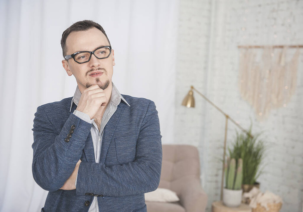 Handsome calm man with eyeglasses standing at home - Zdjęcie, obraz