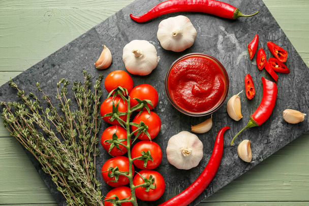 Schüssel mit Tomatensauce und Zutaten auf dem Tisch - Foto, Bild