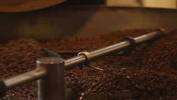 Close up Máquina de torrefação de café de fábrica em operação, torrefação de café transforma as propriedades químicas e físicas de grãos de café verde em produtos de café torrados
. - Filmagem, Vídeo