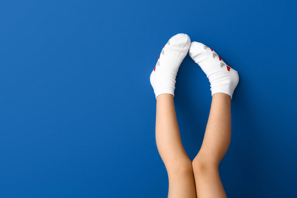 Beine von kleinen Mädchen in Socken auf farbigem Hintergrund - Foto, Bild