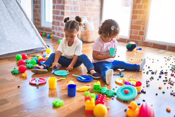 Niños adorables jugando comidas usando comida plástica y juguete de cubiertos en el jardín de infantes
 - Foto, Imagen