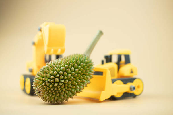 Spielzeug-LKW und Spielzeug-Planierraupe bewegen Durian. - Foto, Bild