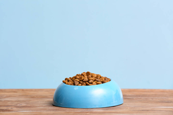 Cuenco con comida seca para mascotas en la mesa
 - Foto, imagen