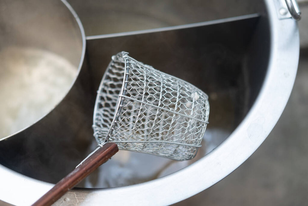 Coador de macarrão de malha de arame de aço tailandês tradicional
 - Foto, Imagem