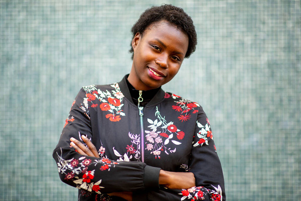 Close up portret młoda afrykańska kobieta uśmiecha się z ramionami skrzyżowane - Zdjęcie, obraz