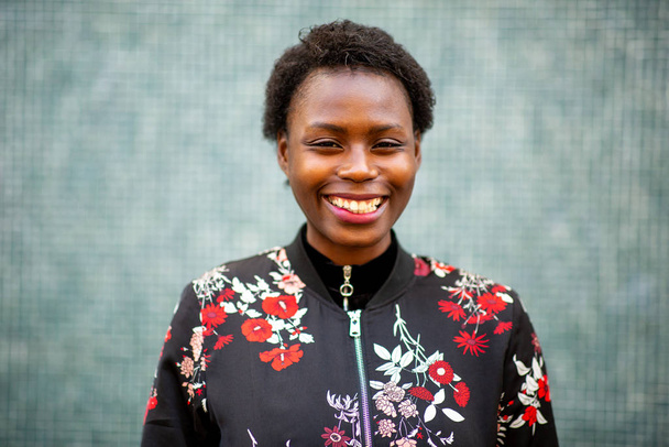 Κοντινό πορτρέτο μιας χαρούμενης νεαρής Αφρικάνας που χαμογελάει. - Φωτογραφία, εικόνα