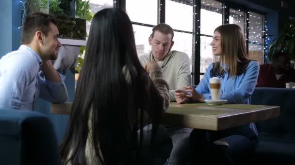 Amigos positivos comunicándose en acogedora cafetería
 - Imágenes, Vídeo