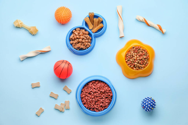 Bols avec nourriture pour animaux et jouets sur fond de couleur
 - Photo, image