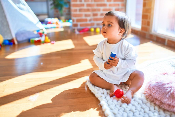 Gyönyörű csecsemő boldog az óvodában körül színes játékok - Fotó, kép