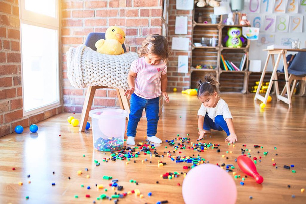 Очаровательные малыши играют со строительными блоками игрушки в детском саду
 - Фото, изображение