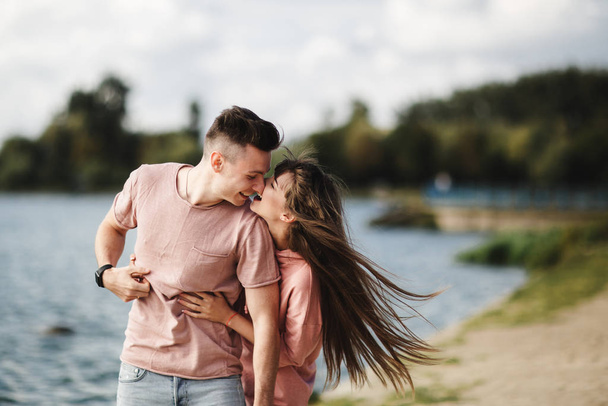 Loving young couple kissing and hugging in outdoors. Love and tenderness, dating, romance, family, anniversary concept. - Photo, Image