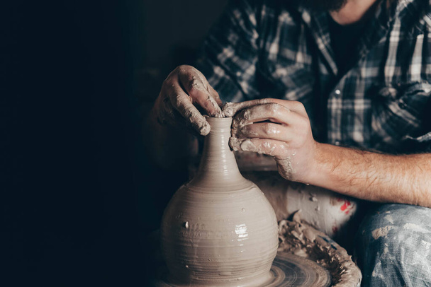 Майстер працює на гончарному колесі, створюючи глечик з глини
 - Фото, зображення
