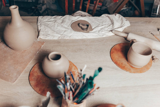 Pottery creative mess on the table. Clay master's workplace - 写真・画像