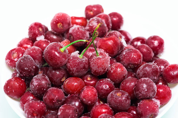 frozen fresh cherries on a white background. an ingredient for smoothies and smoothies. ice crystals on the berry. vertical photo. close up. - Foto, afbeelding