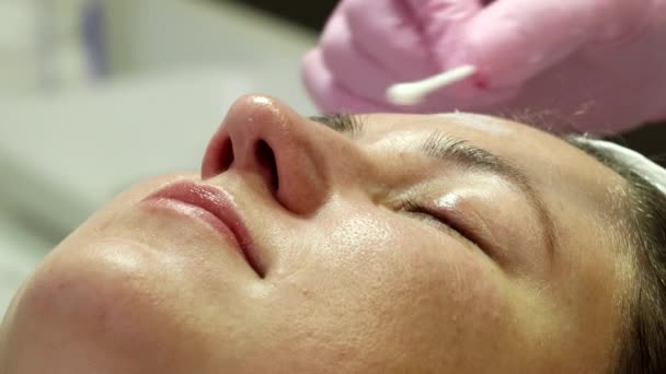 Nainen valmistautuu lasernuorennustoimenpiteeseen salongissa. Kosmetologi-ihotautilääkäri suorittaa photorejuvenation menettelyn. Ammunta on eri näkökulmista
 - Materiaali, video