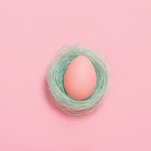 Easter egg in blue  mint sisal nest on pink background  - 写真・画像