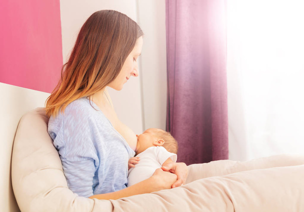 Madre feed neonato bambino bambino sul letto
 - Foto, immagini