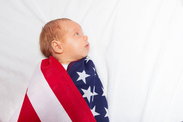 Portrait of calm baby infant wrapped in USA flag - Fotografie, Obrázek