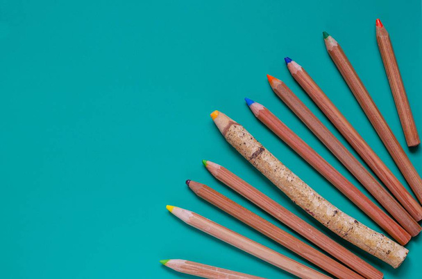 Десять разноцветных карандашей на бирюзовом фоне
. - Фото, изображение